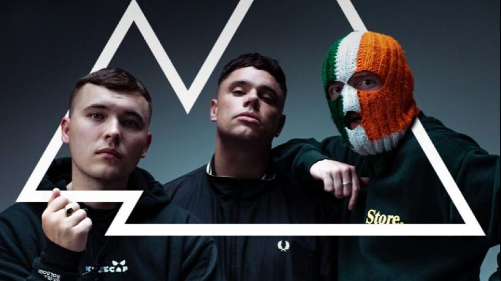 Tres músicos, dos con la cara visible y uno con pasamontañas tricolor irlandés, visten ropa casual. Diseño gráfico superpuesto.