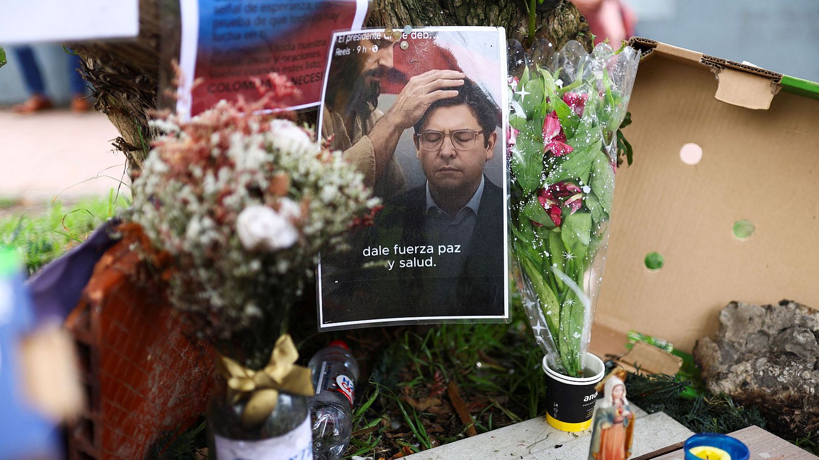Imagen de un altar improvisado con una figura religiosa imponiendo la mano sobre una persona.  Se lee la frase "dale fuerza, paz y salud".