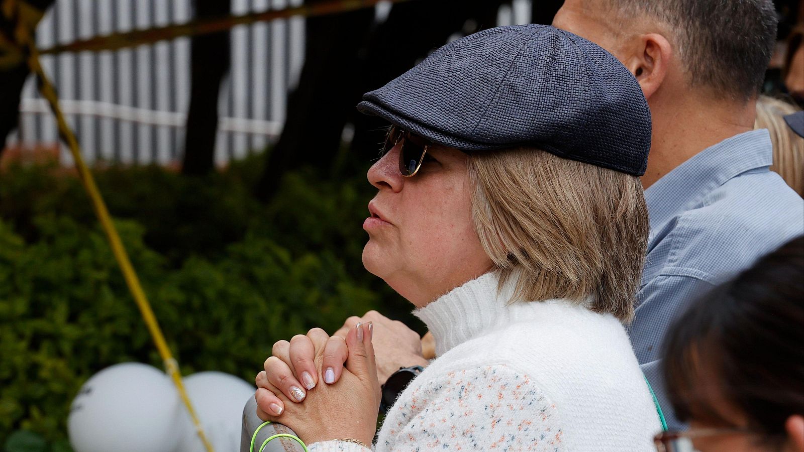 Una mujer pidiendo a las puertas de la Fundación Santa Fe por la salud de Uribe Turbay