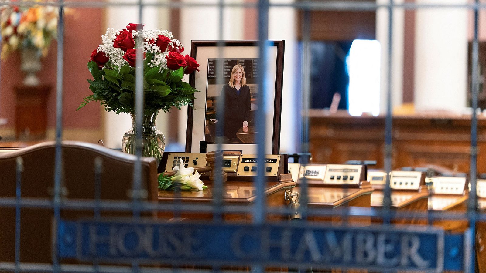 Flores y un retrato de la legisladora Melissa Hortman sobre su escritorio en la Cámara de Representantes de Minnesota