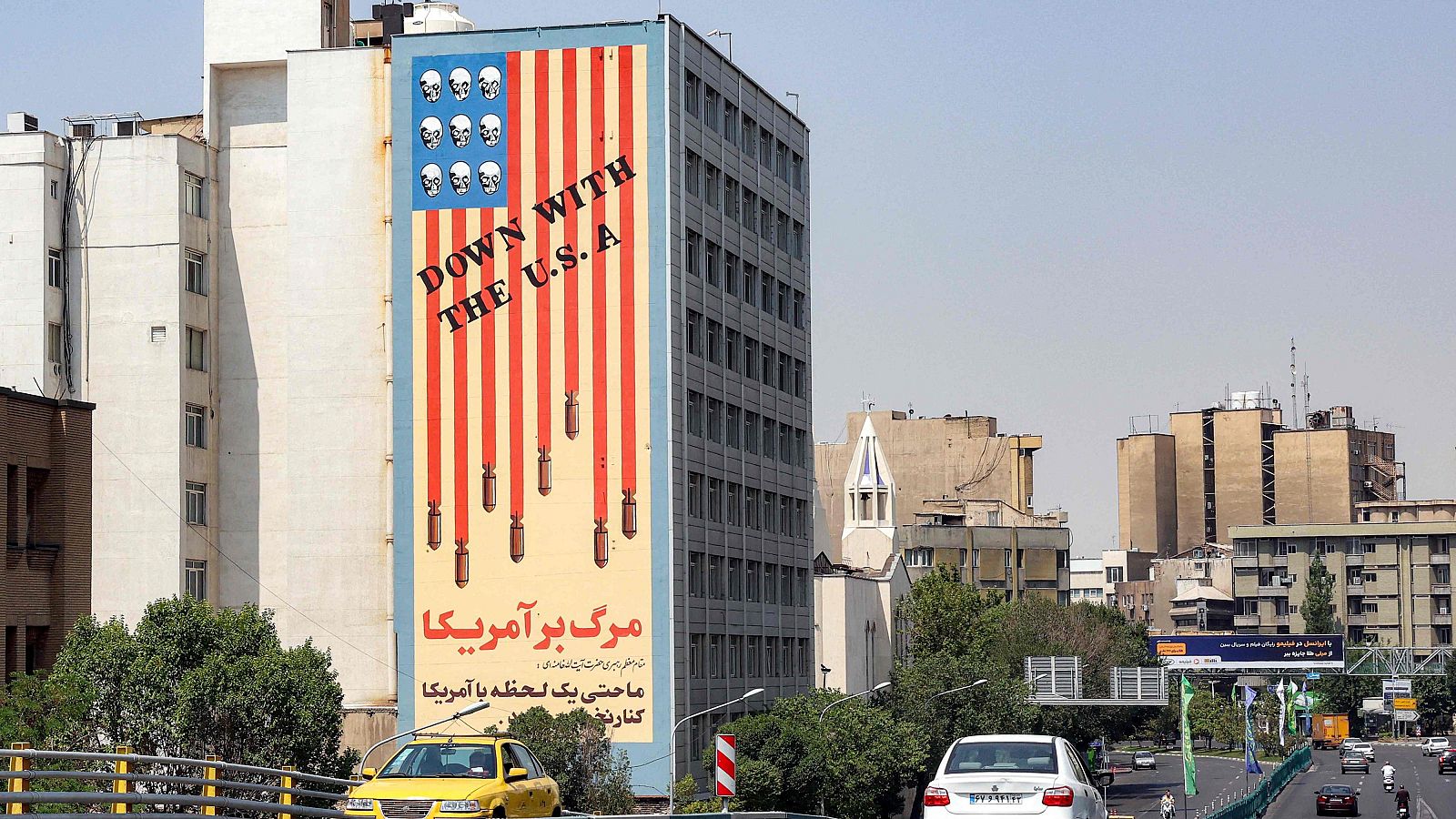Vista de un mural con una bandera estadounidense y el lema "Abajo EE.UU." en el lateral del edificio de la Organización Nacional de Pruebas Educativa