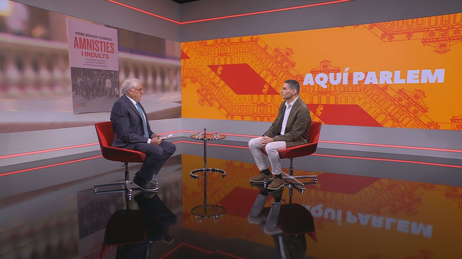 Lluís Falgàs i Pere Bosch asseguts a les butaques del plató de l''Aquí Parlem'