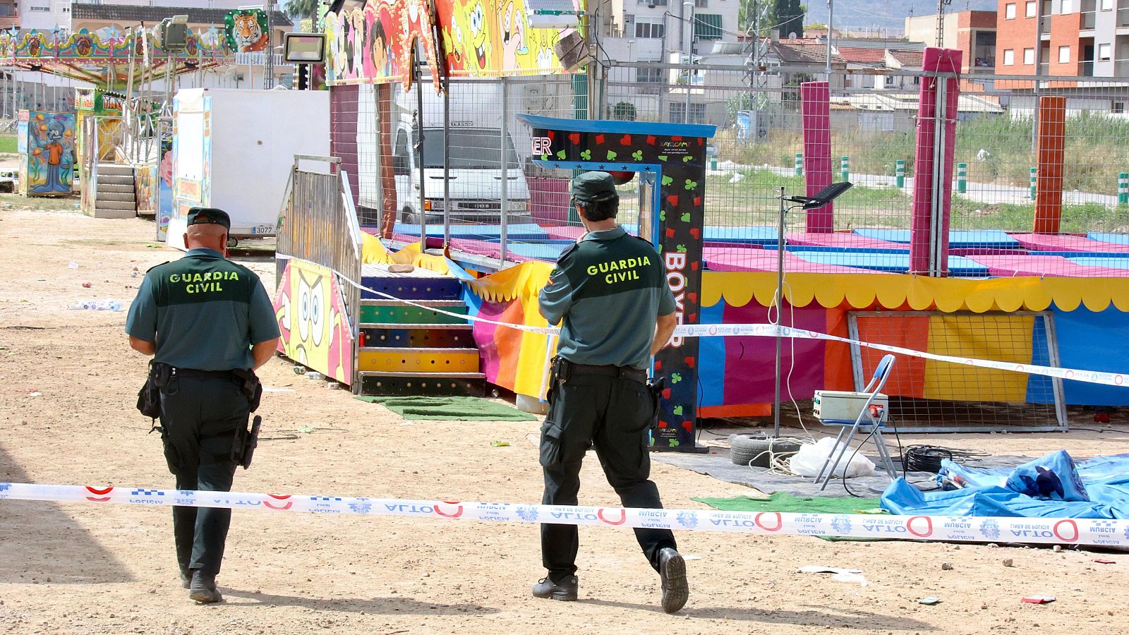 Agentes de la Guardia Civil precintan este domingo las camas elásticas del recinto ferial de la pedanía murciana de Alquerías después de que una niña de dos años falleciera esta madrugada al recibir una descarga eléctrica. EFE/ Juan Carlos Caval