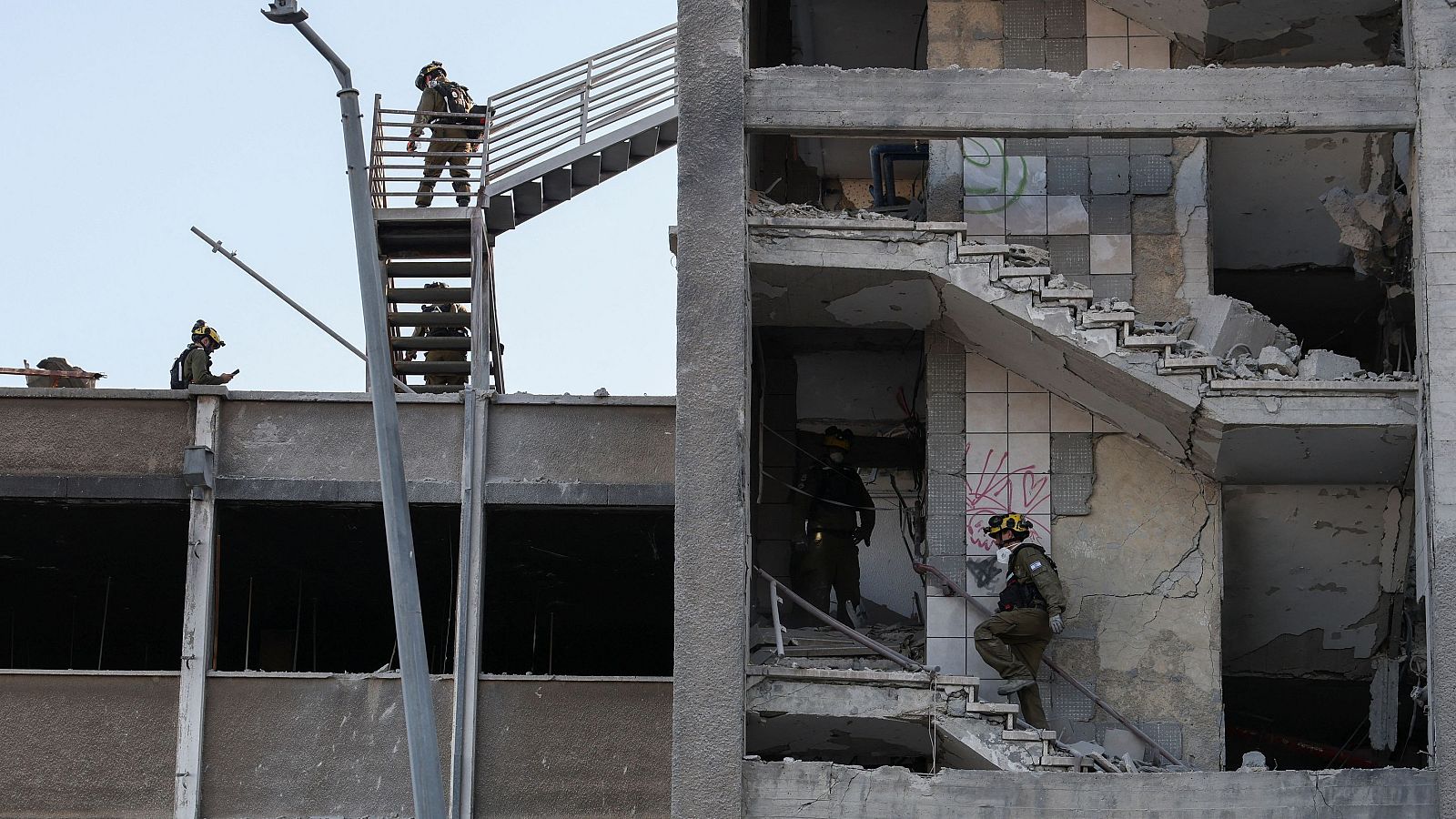 Personal de emergencias trabaja en un edificio dañado tras el ataque con misiles de Irán contra Israel