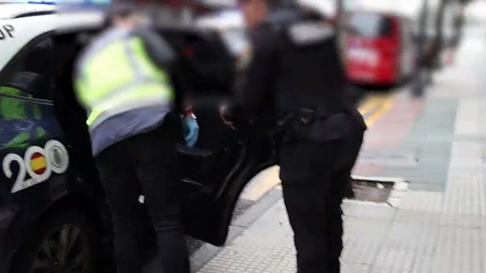 Agentes de la Policía Nacional instroducen en un coche policial a un detenido acusado de explotación sexual