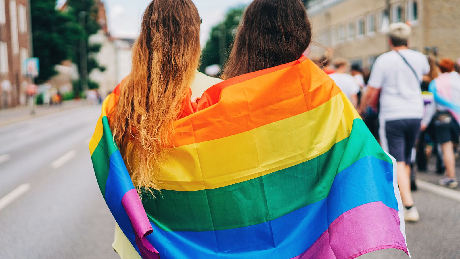 Dos amigas envueltas en una bandera LGBT