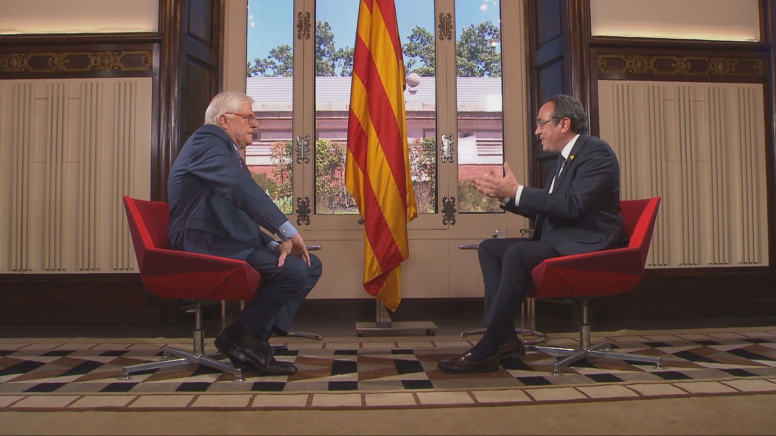 Lluís Falgàs i Josep Rull asseguts a unes cadires a una sala del Parlament