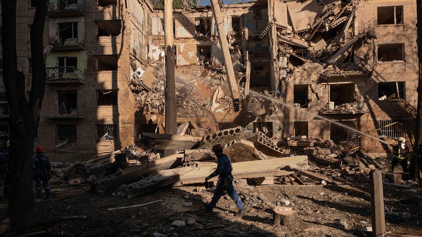 Bomberos ucranianos trabajan en el lugar de un edificio de apartamentos alcanzado por drones y misiles rusos