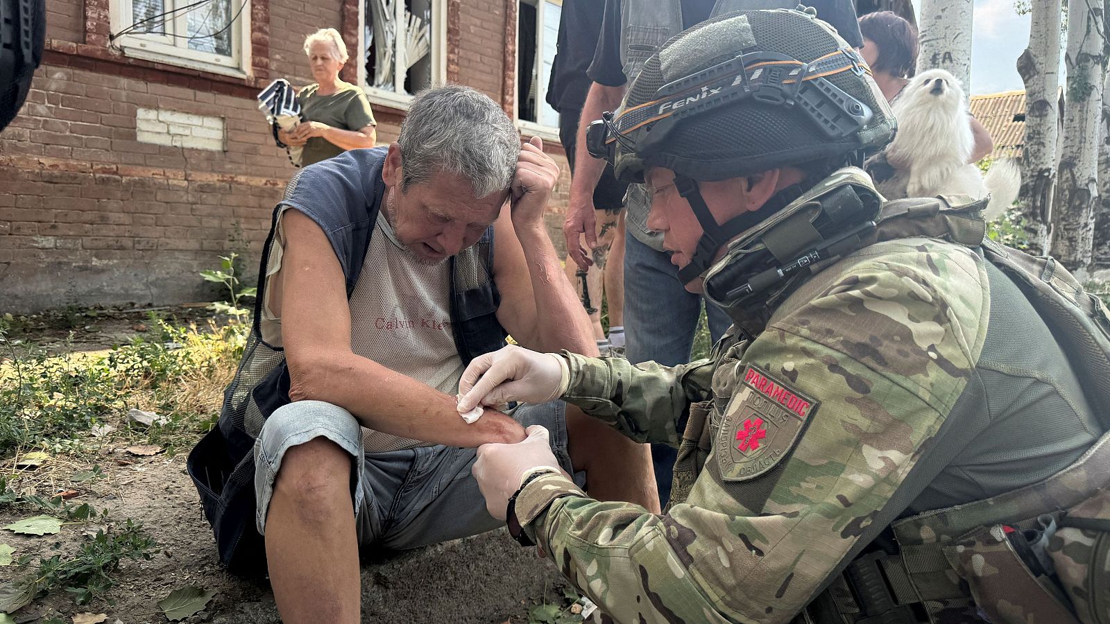 Un miembro de la policía ucraniana atiende a un residente en el lugar de un ataque con drones rusos