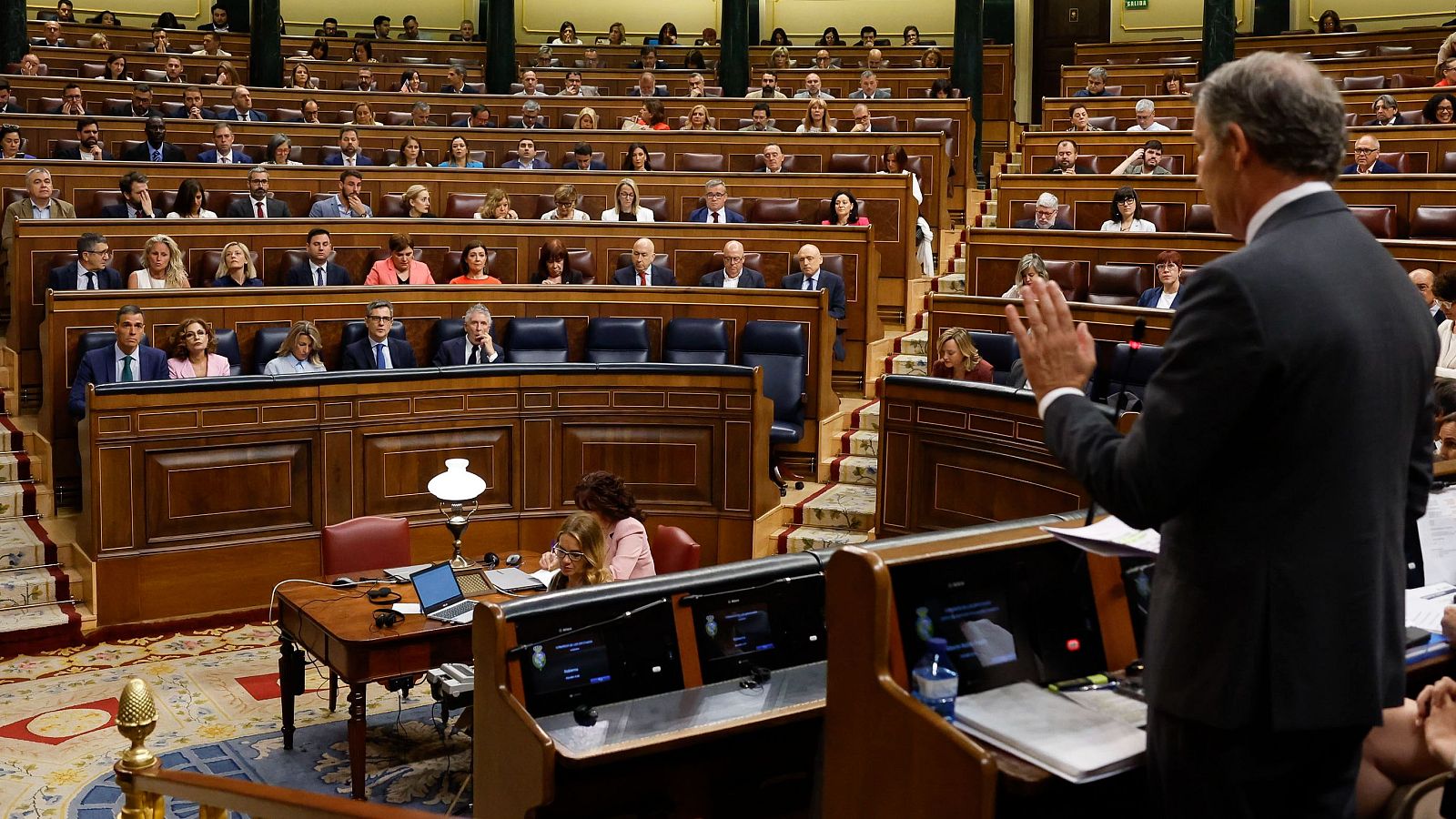 El presidente del Gobierno, Pedro Sánchez (i, al fondo), escucha la intervención del líder popular, Alberto Núñez Feijóo (d)