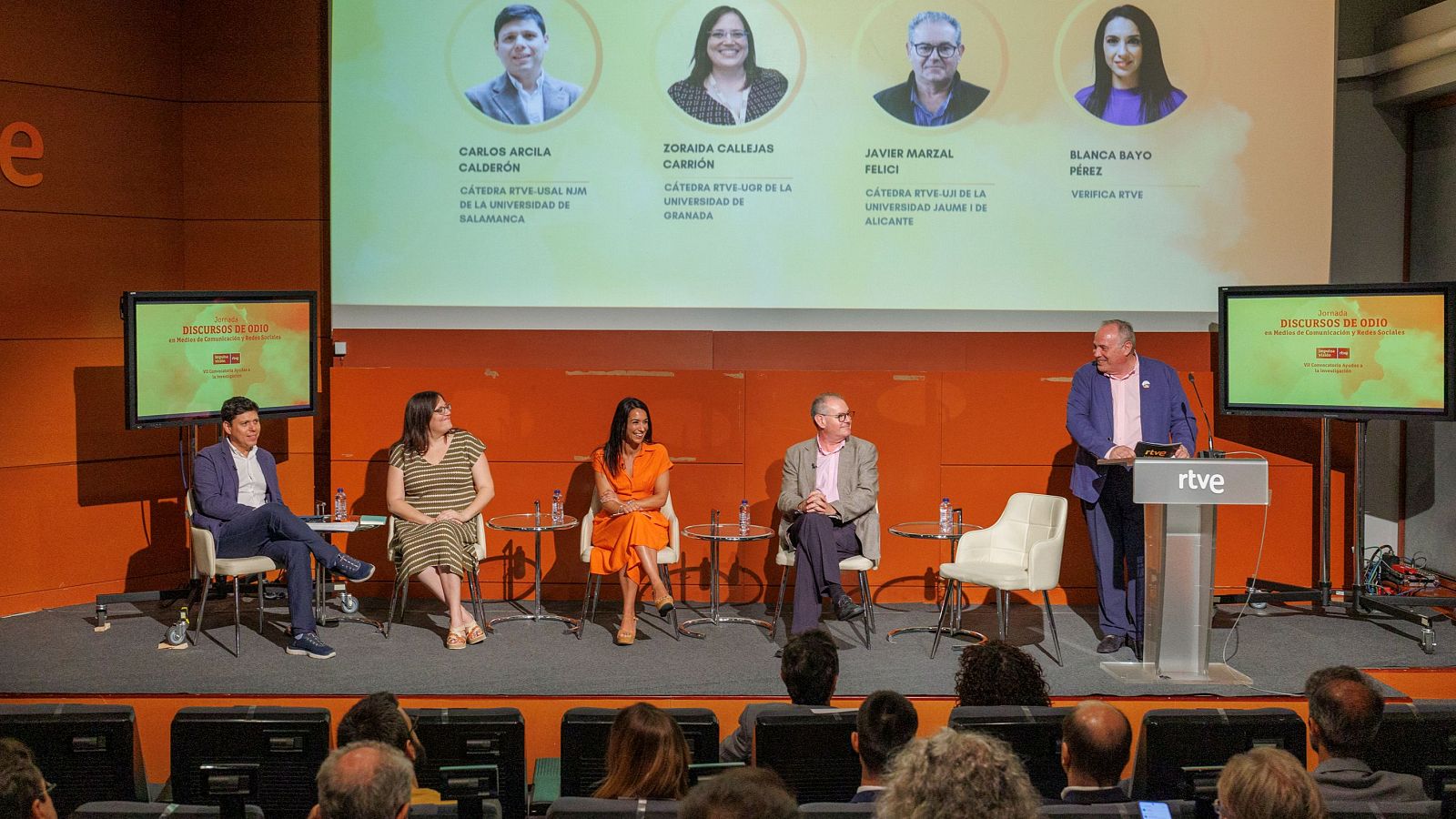 Jornada sobre discursos de odio con ponentes de diferentes Cátedras RTVE y Verifica RTVE.  Se ven varias personas en el escenario y público asistente.