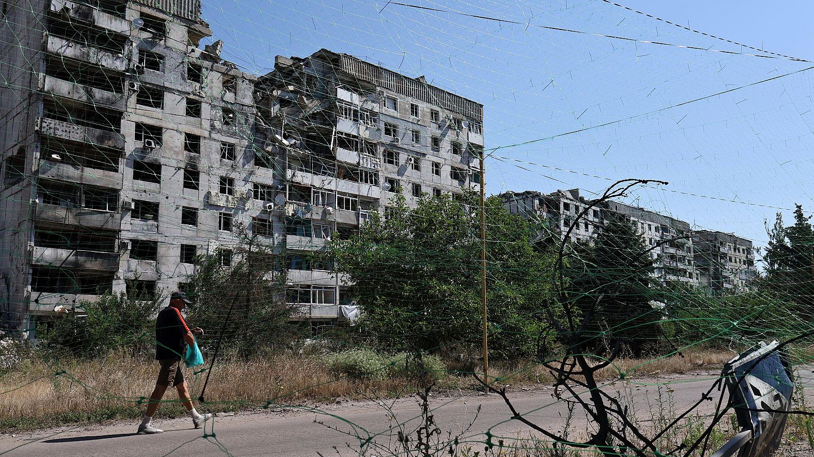 Un hombre camina bajo una red antidrones en Orejov, región de Zaporiyia