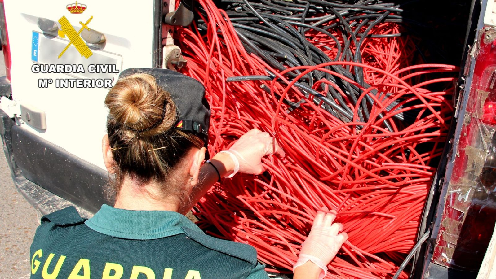 Una agente junto a una furgoneta en la que se intervinieron kilos de cableado de cobre