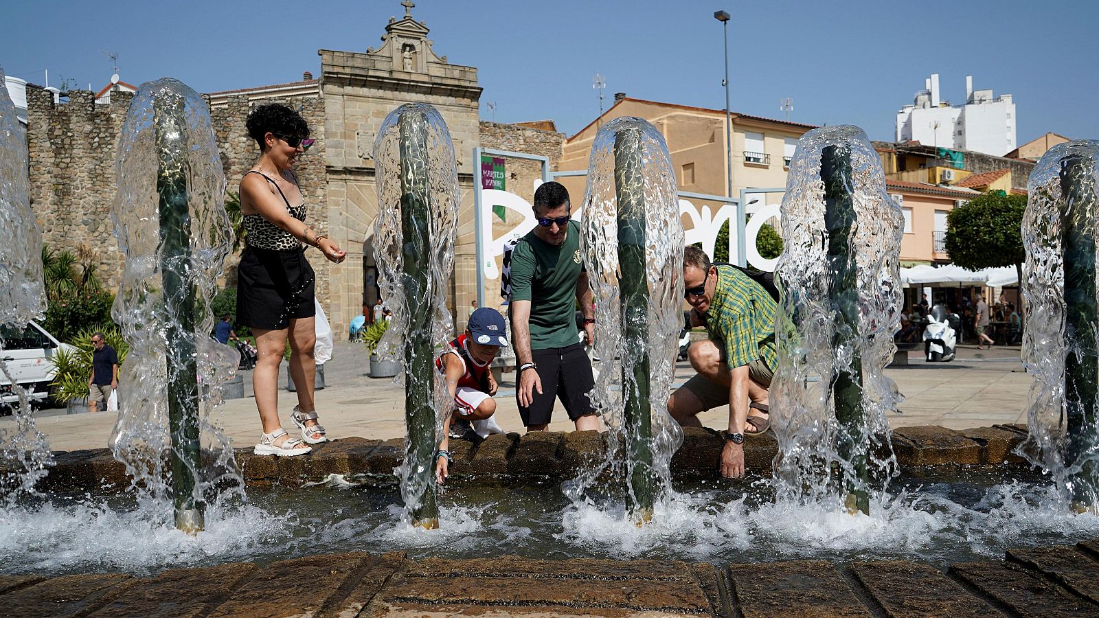 Una familia se refresca en una fuente en Plasencia