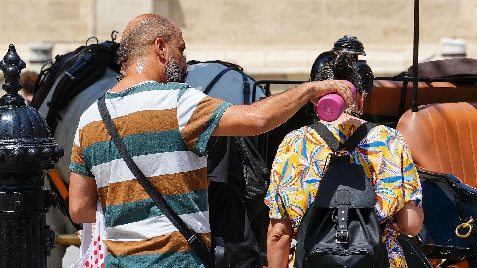 Peatones se refrescan en las calles de Sevilla durante la ola de calor