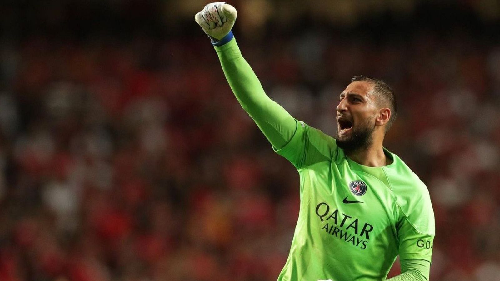 Portero del PSG celebrando con el puño cerrado, vistiendo la camiseta verde con el logo de Qatar Airways.  Fondo borroso de estadio.  Posible despedida.