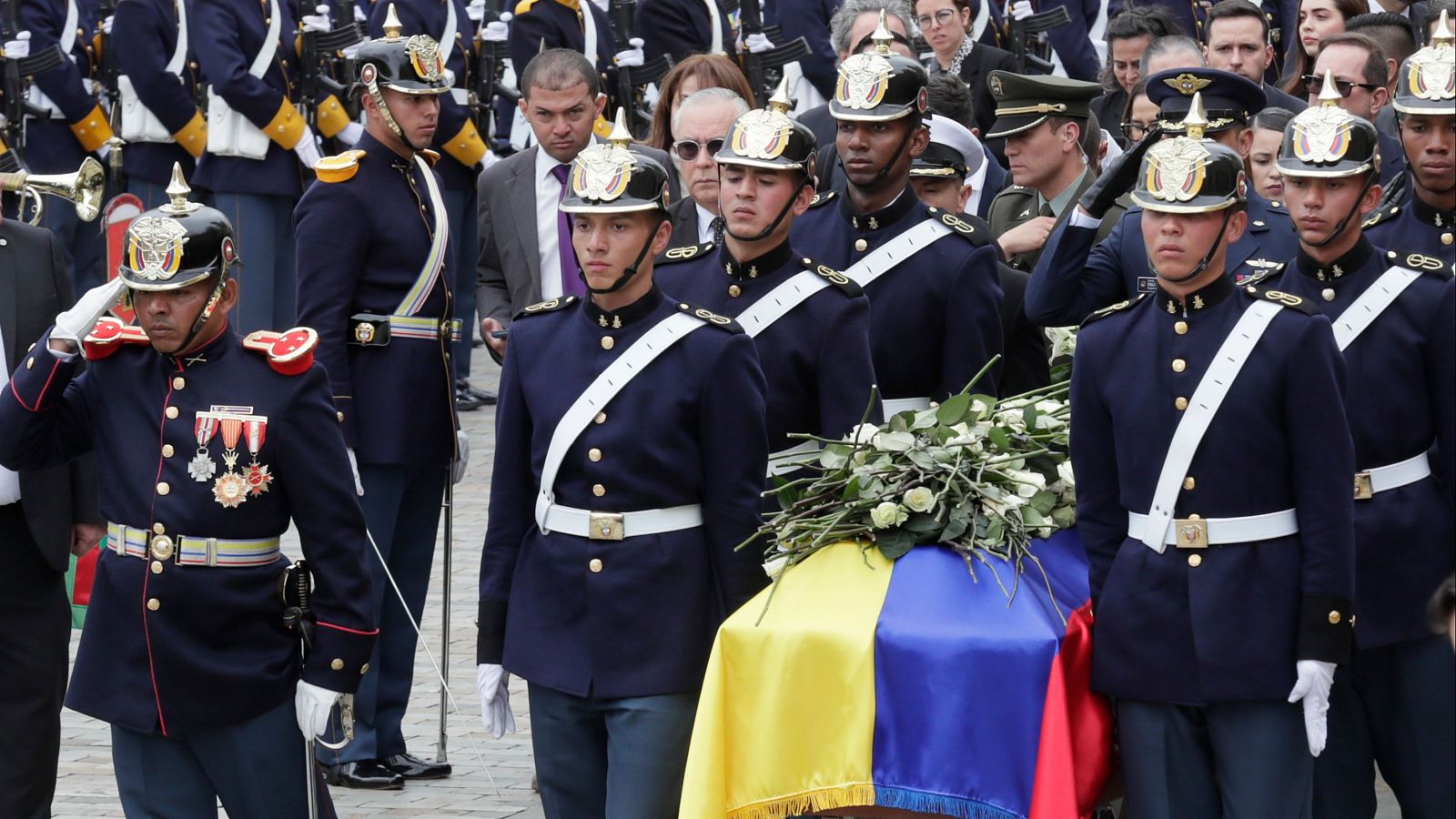 Integrantes del Batallón Guardia Presidencial cargan el féretro de Miguel Uribe Turbay hacia un coche fúnebre