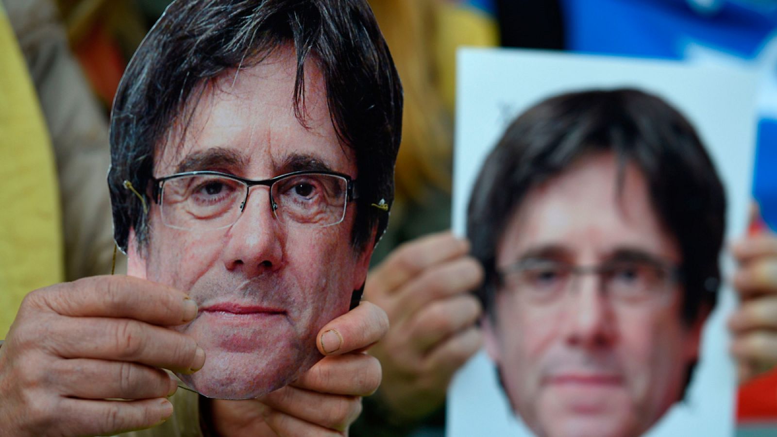 Manifestantes independentistas sujetan máscaras de Carles Puigdemont en un acto reivindicativo en Barcelona
