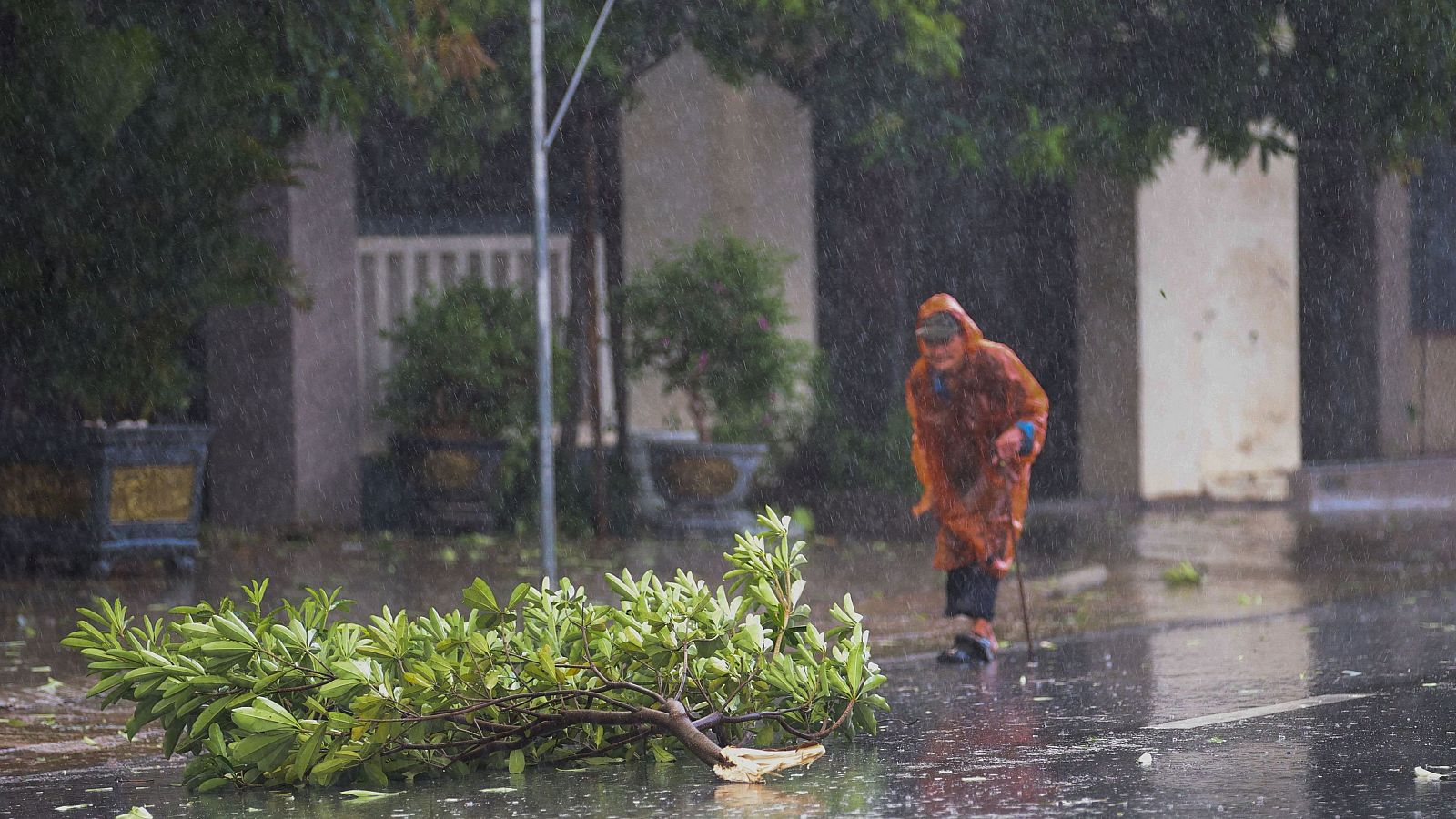 Una mujer caminando por la calle mientras se acerca el tifón