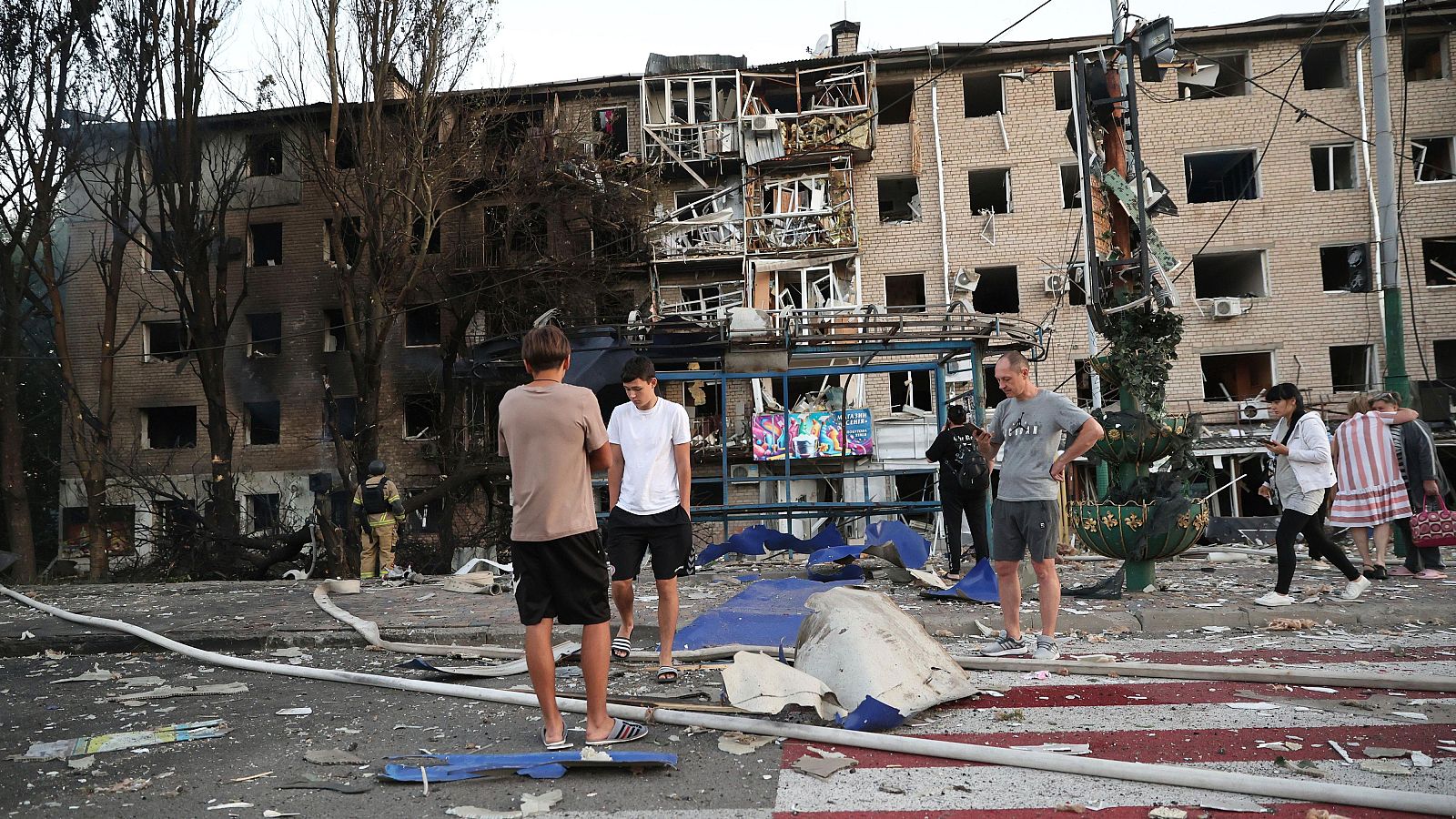 Varias personas cerca de edificios dañados tras un ataque aéreo ruso en Zaporiyia, Ucrania