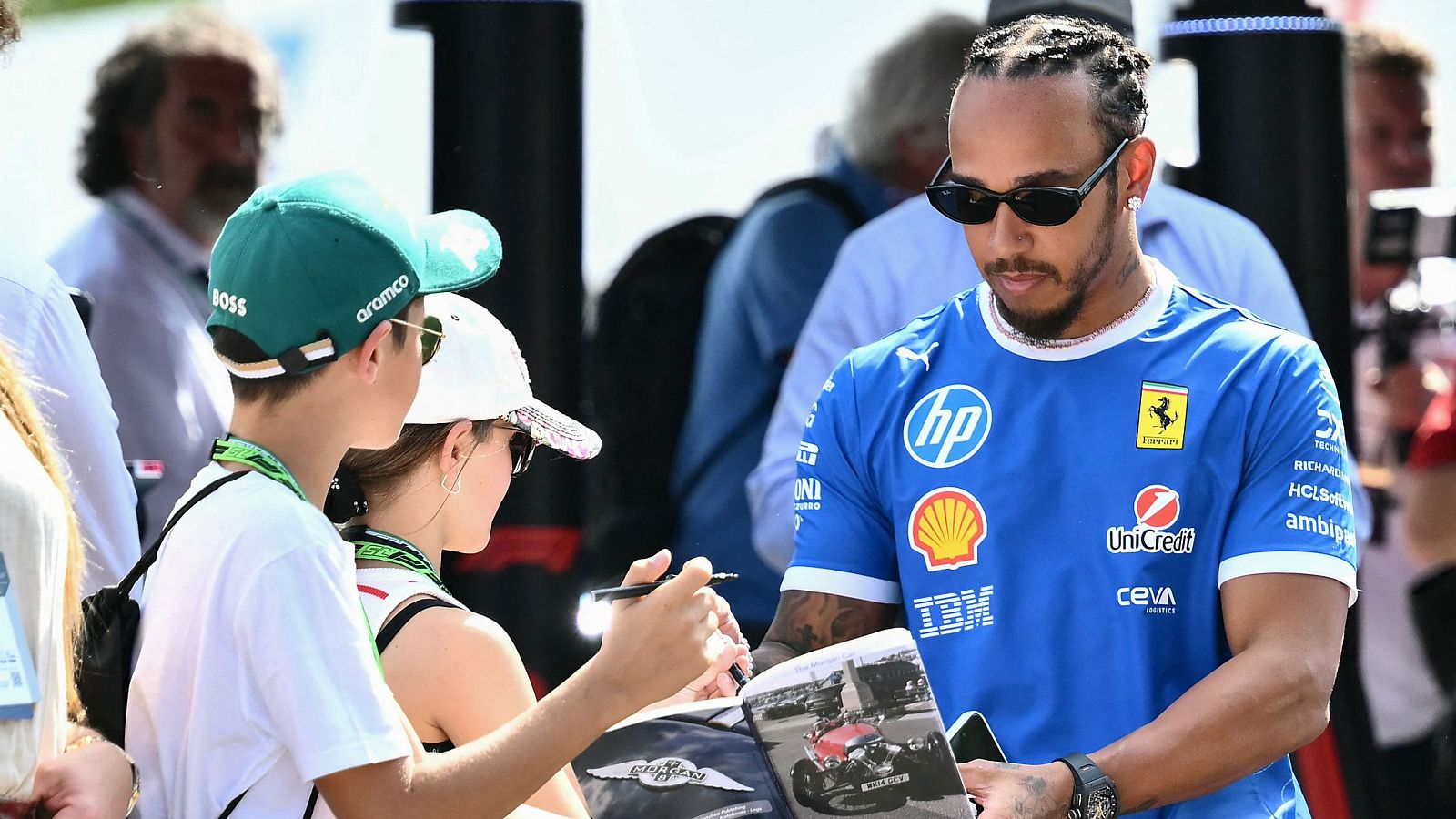 El piloto de Ferrari Lewis Hamilton firma un autógrafo en Monza.