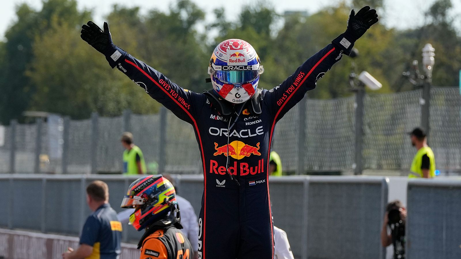 Verstappen celebra su victoria con los brazos en alto, luciendo su mono de carreras de Red Bull con los logos de Oracle, Mobil y Honda. Su casco con el número 6 también es visible.