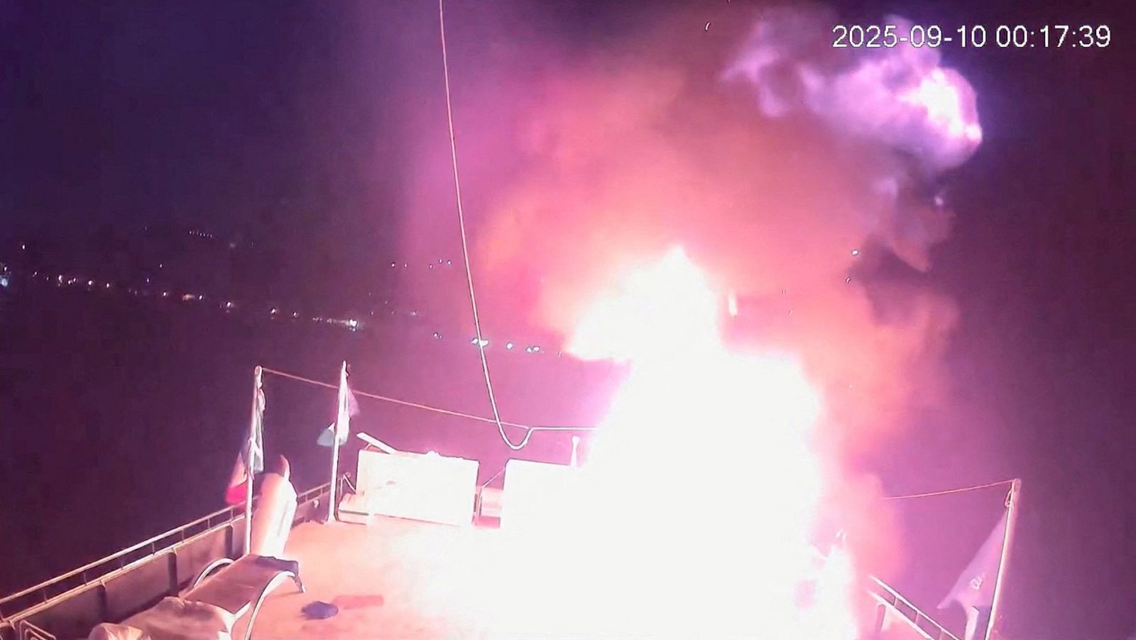Imagen nocturna de CCTV mostrando un incendio en la cubierta de un barco.  Llamas y humo visibles.  Aparentemente, situación de emergencia.