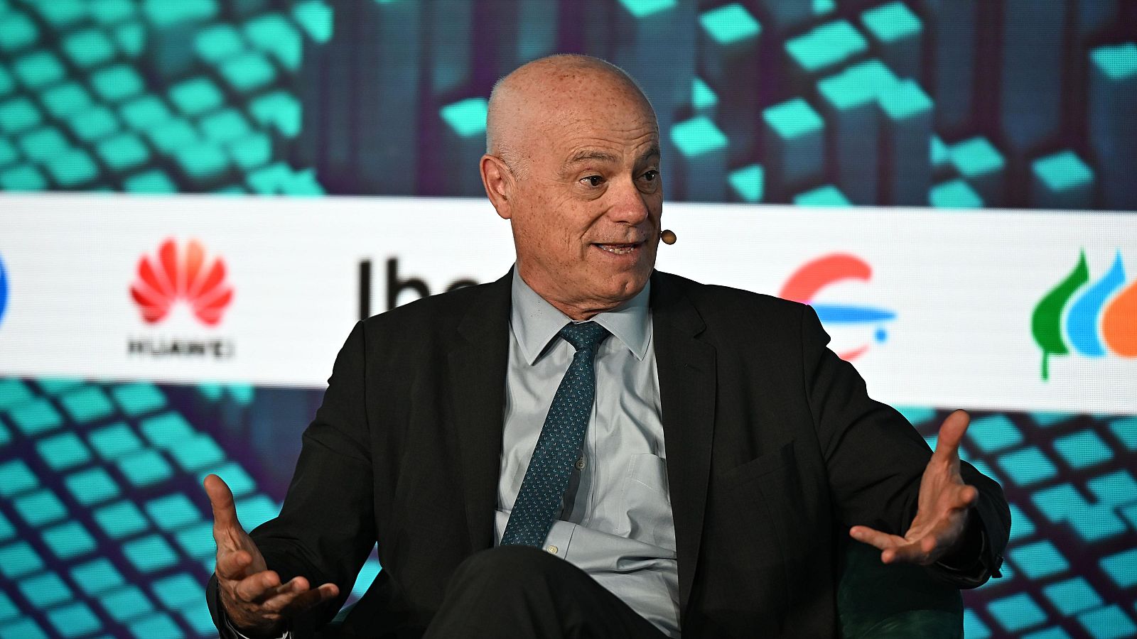 Presidente de la Autoridad Bancaria Europea sentado, gesticulando mientras habla en un evento. Viste traje oscuro y camisa clara con corbata.