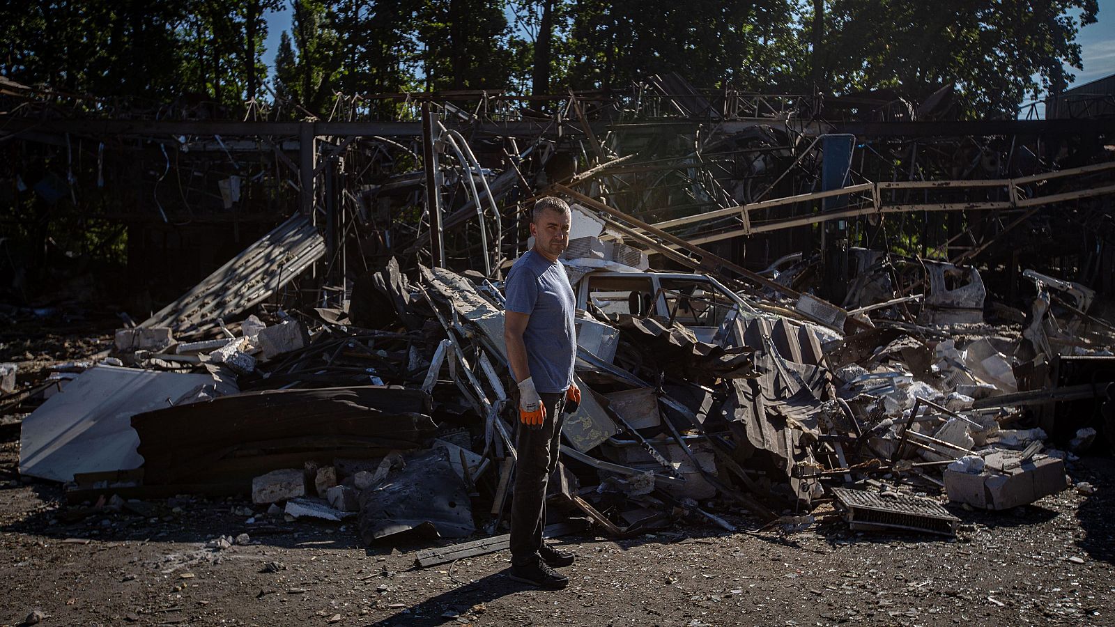 Un trabajador ucraniano se encuentra entre los restos de un taller de reparación de automóviles destruido por un ataque con drones rusos