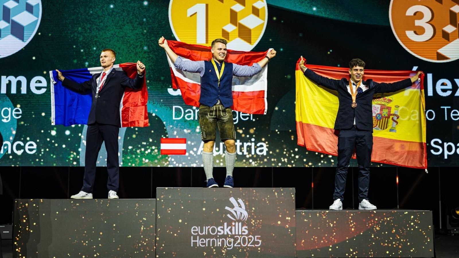Podio Euroskills Herning 2025: tres ganadores con medallas; banderas de Francia, Austria y España. Bronce para España en refrigeración y aire acondicionado.