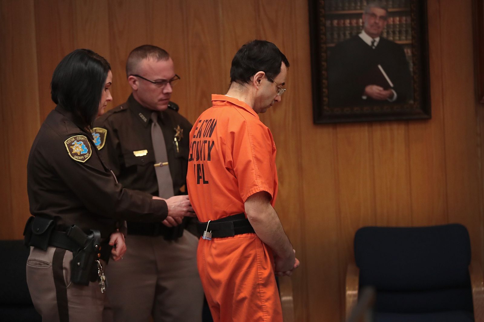 El exmédico estadounidense Larry Nassar es conducido fuera de la sala esposado tras escuchar el veredicto de su último juicio