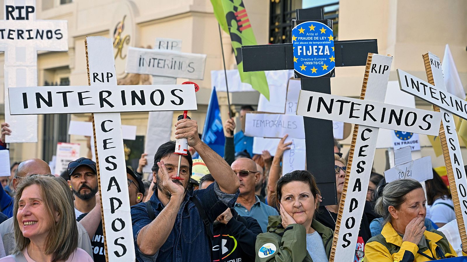 En la imagen se observa una protesta con personas que sostienen carteles con mensajes relacionados con la situación laboral. Se destaca una pancarta con la frase "FRAUDE DE LEY" y el logo de la Unión Europea, en un contexto de preocupación laboral.