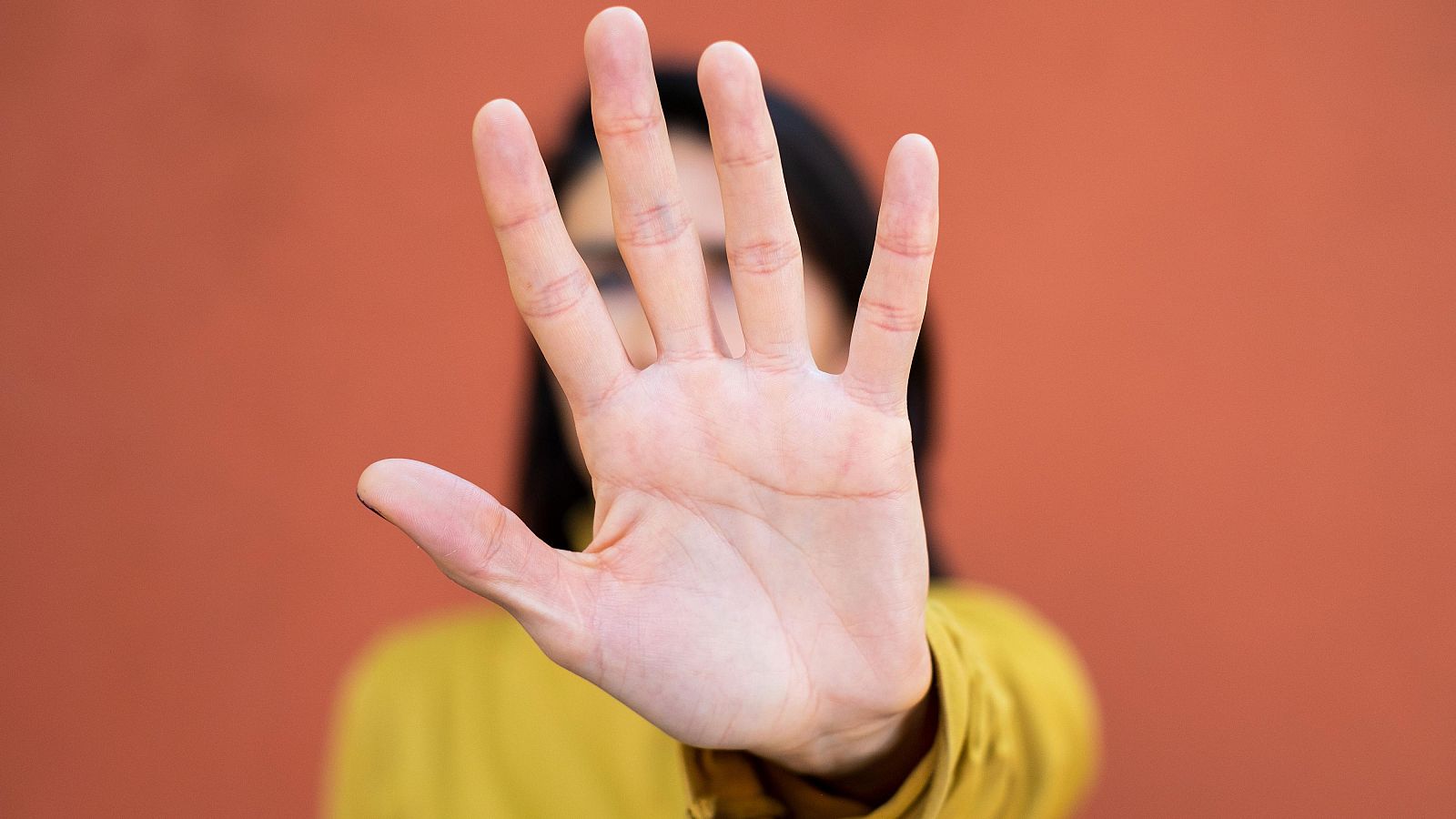 Una mujer tapándose la cara en contra de la violencia