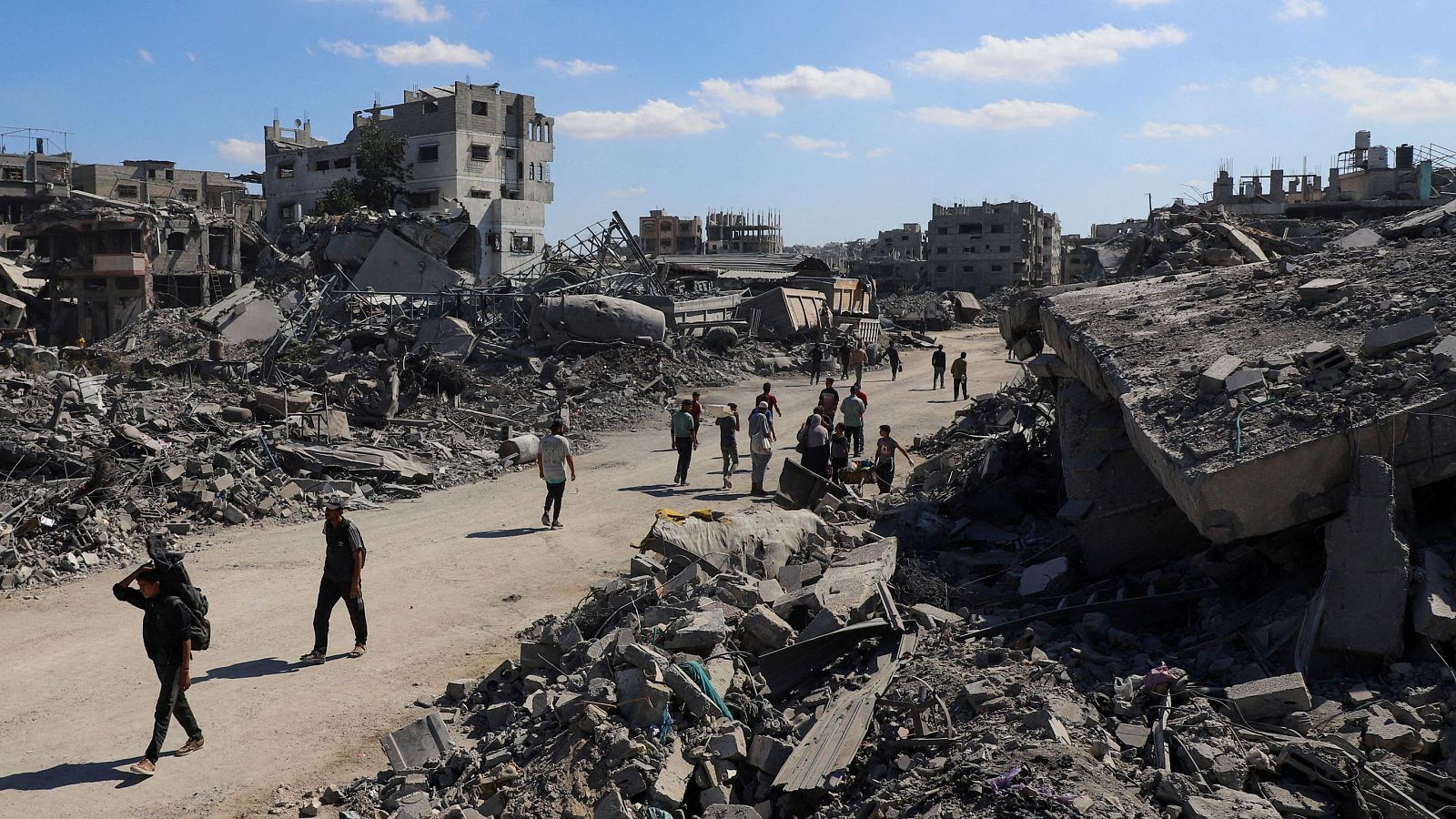 Palestinos caminan entre los escombros de edificios destruidos, en medio de un alto el fuego entre Israel y Hamás, en la ciudad de Gaza, el 14 de octubre de 2025.