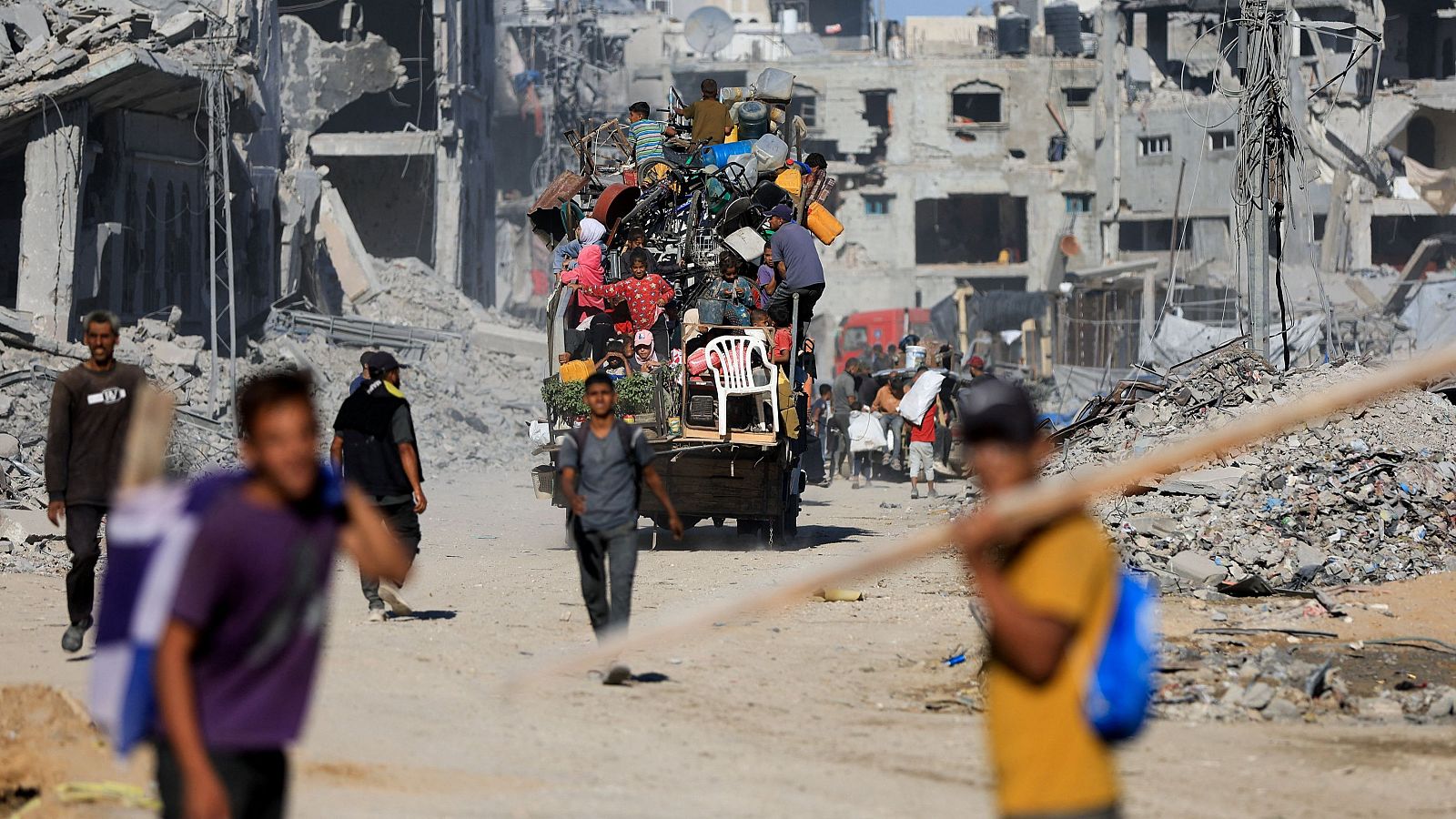 Palestinos pasan entre los escombros de edificios destruidos