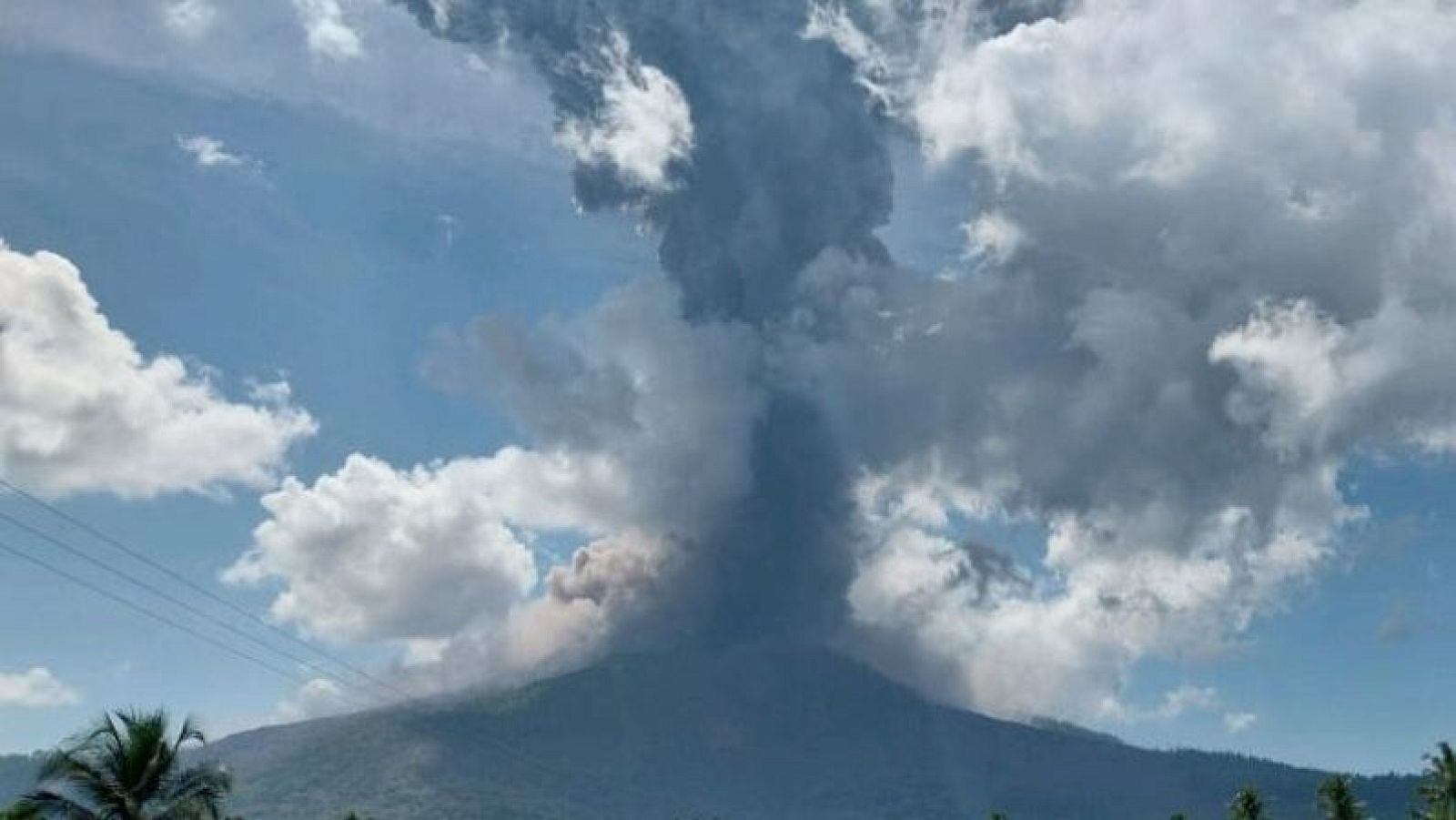 El volcán Lewotobi Laki-Laki en Indonesia entra en erupción, lanzando una densa columna de humo y ceniza hacia un cielo parcialmente cubierto de nubes. La fotografía fue tomada el miércoles 15 de octubre de 2025.