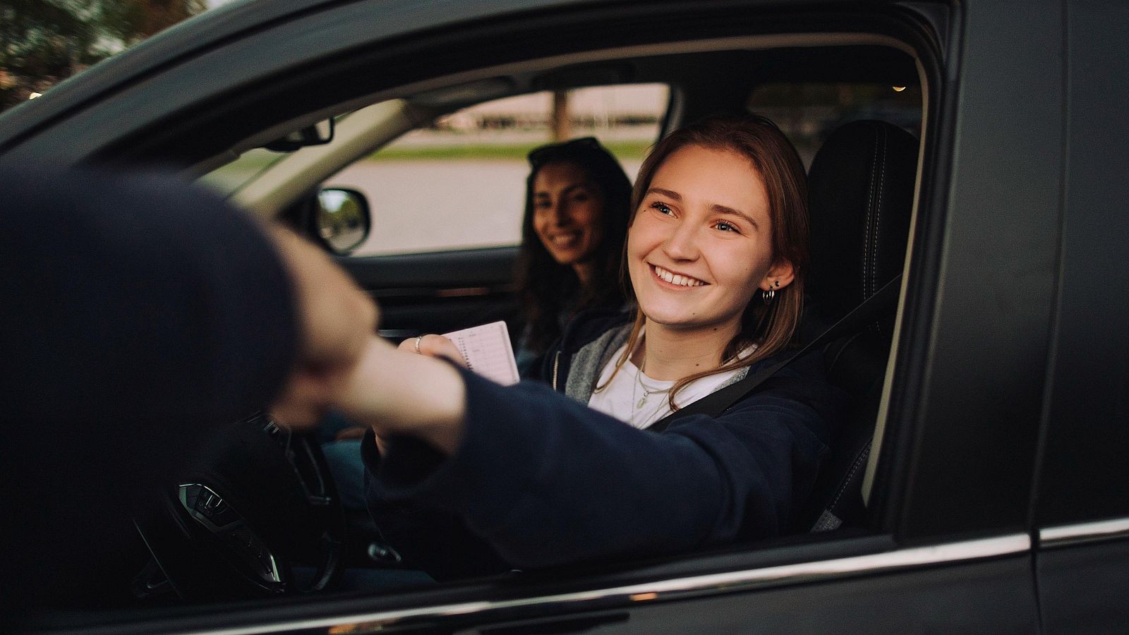 Una joven muestra su carné de conducir
