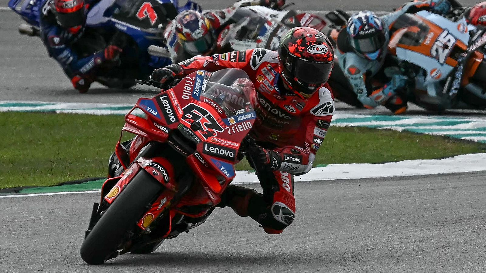 'Pecco' Bagnaia, con el número 63, lidera la carrera al sprint de MotoGP, pilotando una moto roja Ducati con detalles en blanco y negro, en una curva de la pista, con otros pilotos detrás.
