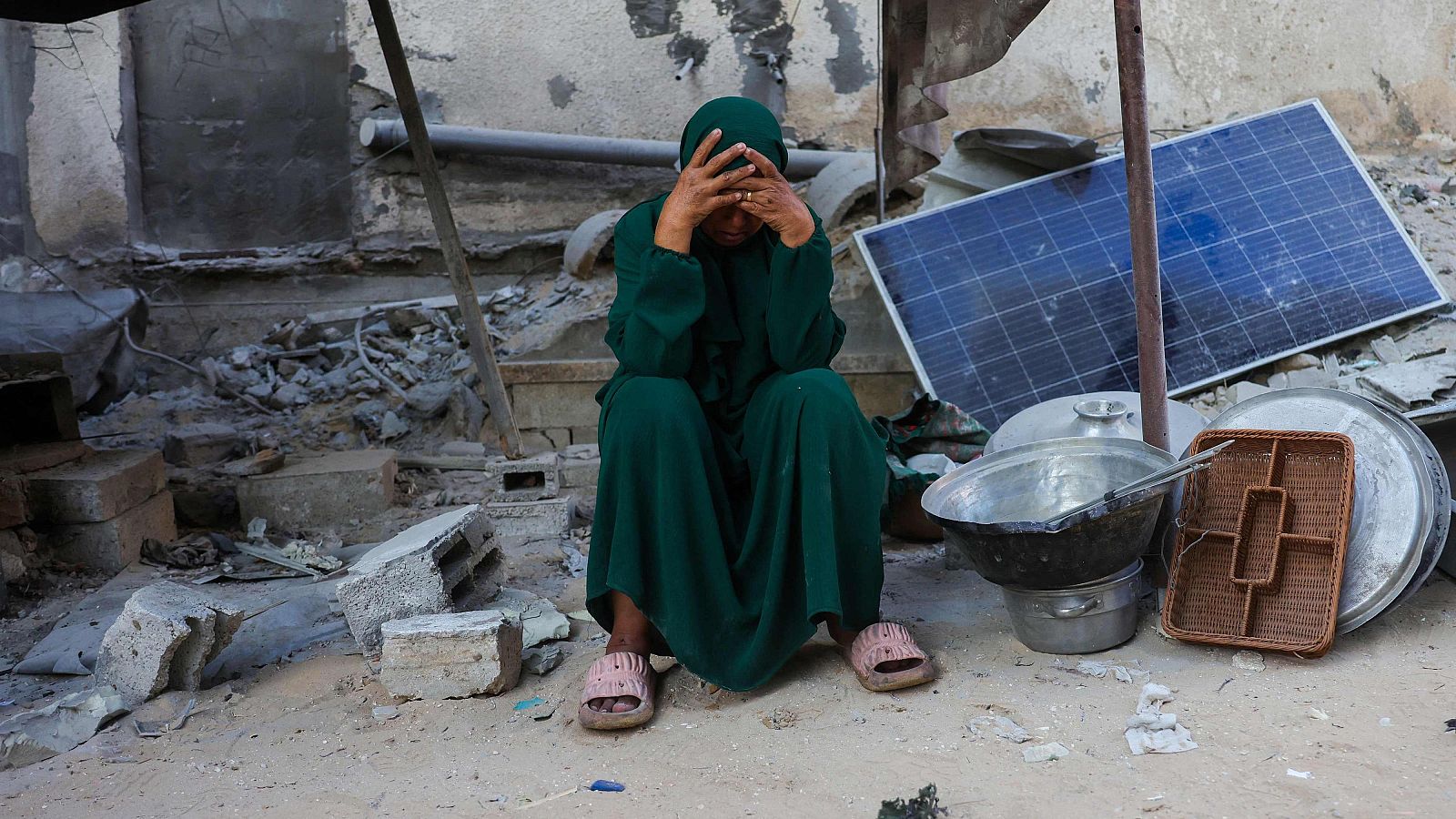 Una mujer sentada junto a sus utensilios rescatados de los escombros de una casa destruida en un ataque israelí en Jan Yunis, en el sur de la Franja de Gaza, el 29 de octubre de 2025.