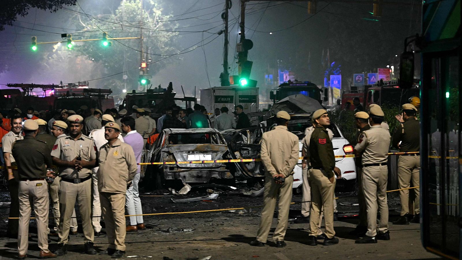 Personal de seguridad junto a vehículos calcinados en el lugar de la explosión en Delhi