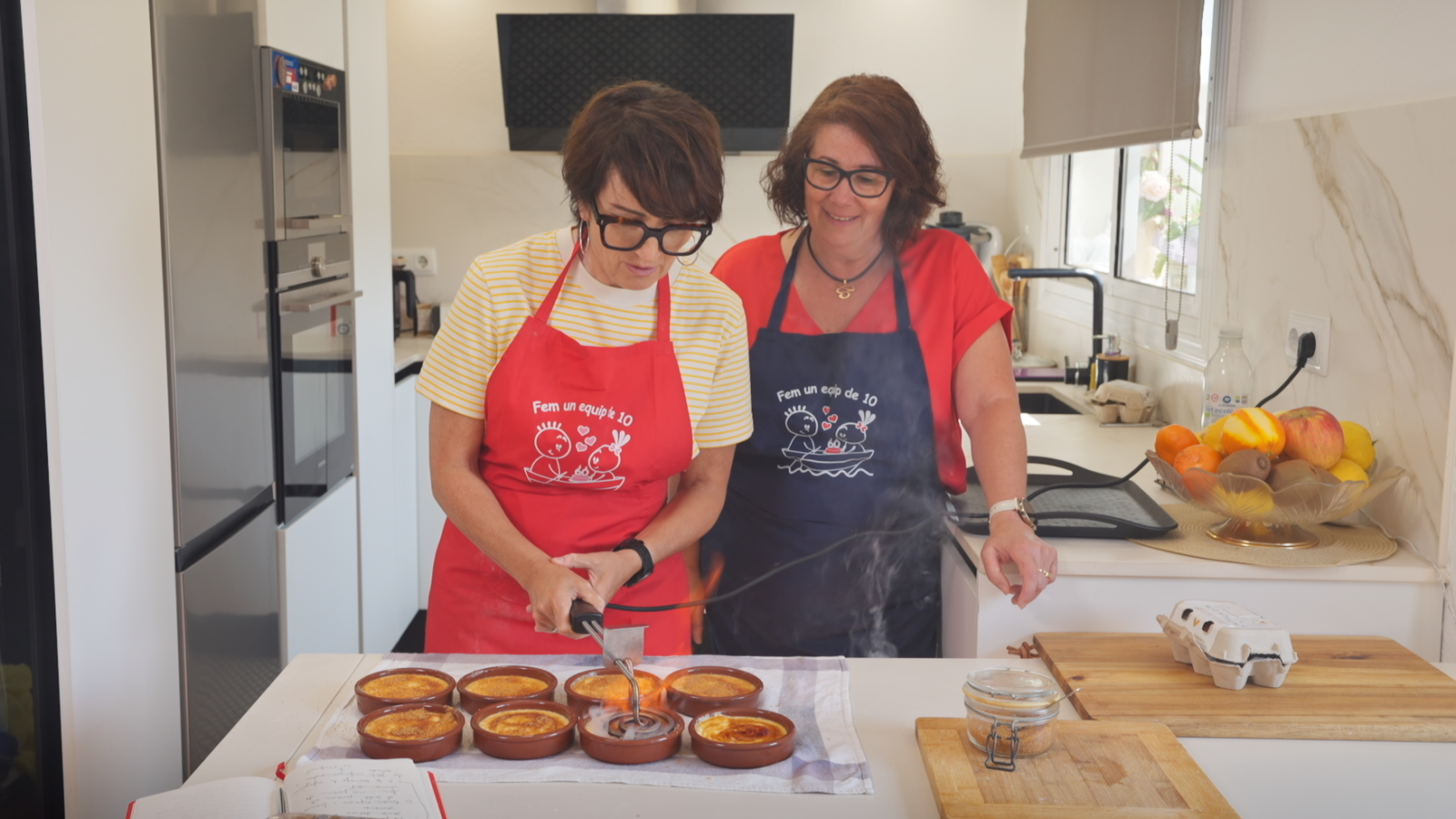 Sílvia Abril i Mari Lanza cuinant vuit cremes catalanes en cassoles de terrissa al poble de Breda
