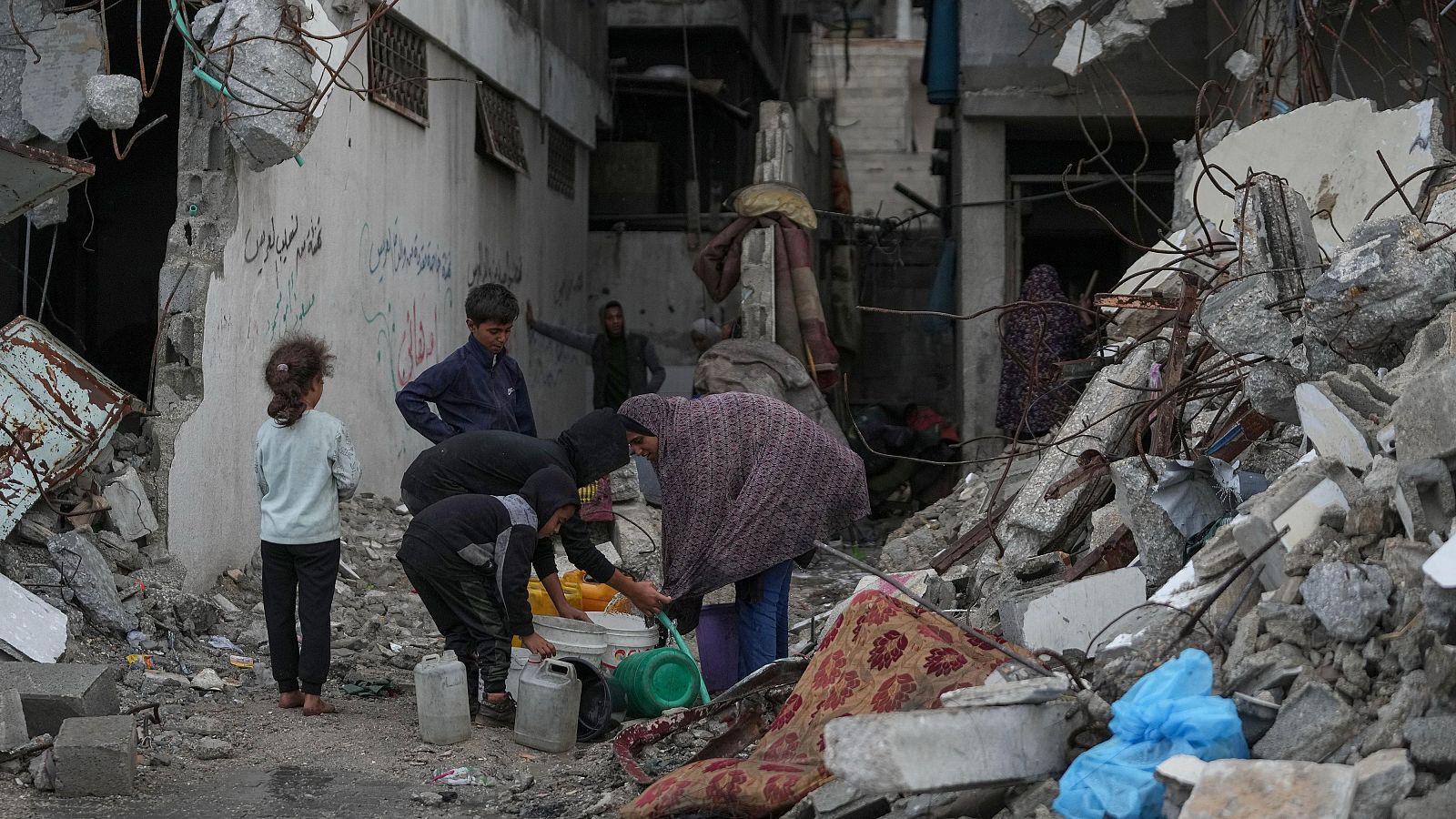 Palestinos recogen agua de una manguera durante una tormenta en el barrio de Sheikh Radwan, en la ciudad de Gaza