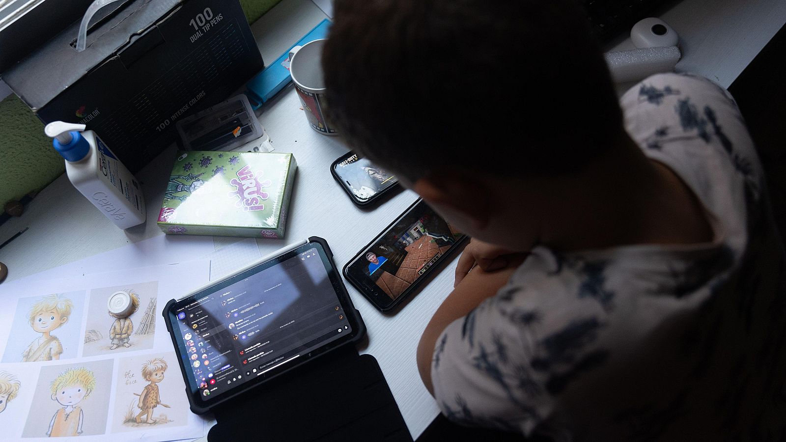 Un niño usa el teléfono móvil y una tablet