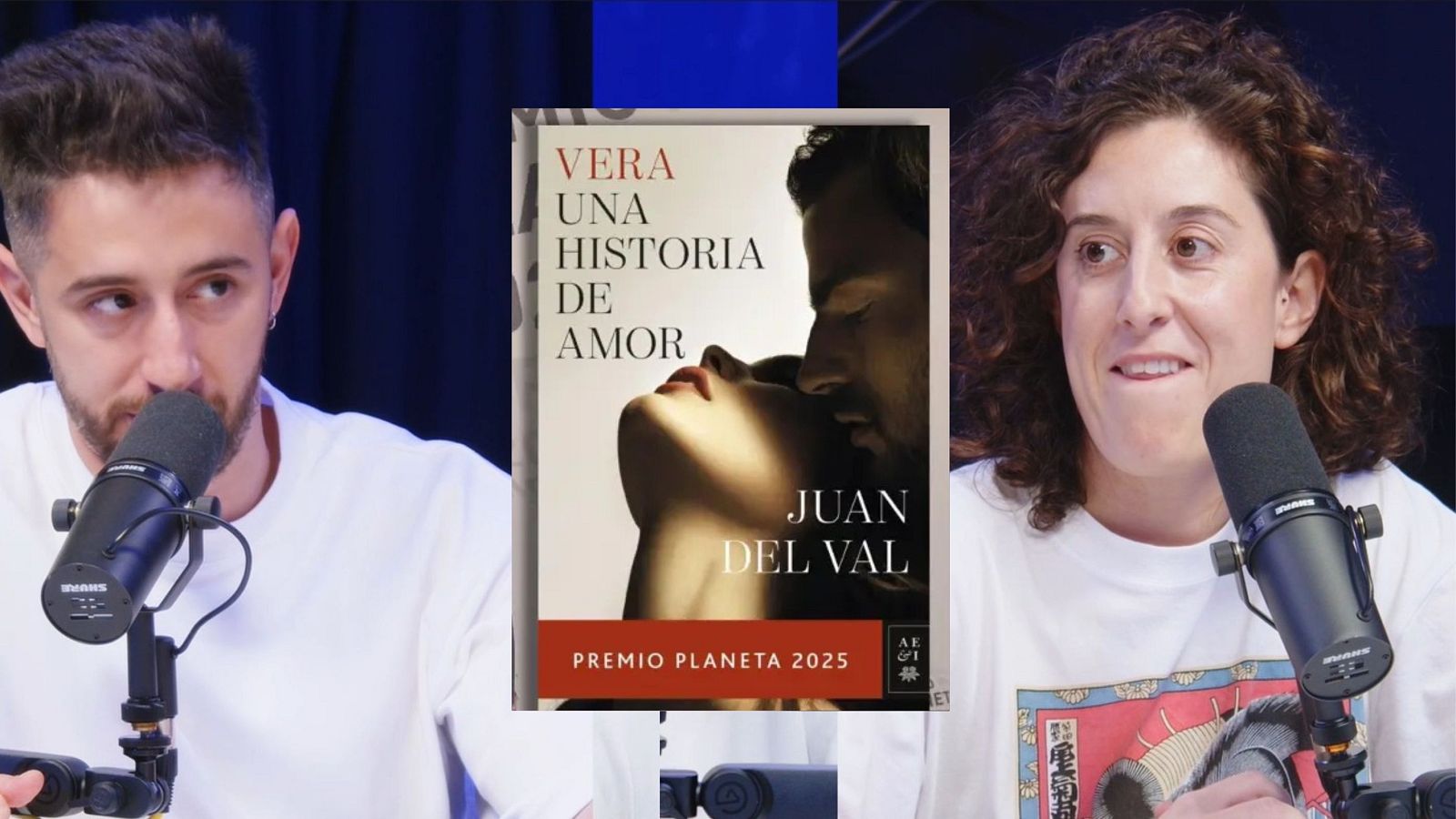 En un estudio de grabación, dos personas sentadas frente a micrófonos profesionales, con la portada de un libro en el centro. Uno de ellos lleva barba y camiseta blanca, mientras que la otra persona tiene el pelo rizado y una camiseta estampada.