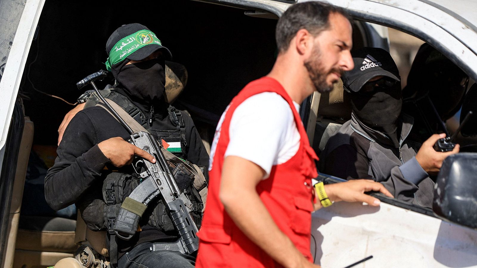 Militantes de Hamás se sientan dentro de un vehículo mientras escoltan a miembros de la Cruz Roja hacia una zona dentro de la llamada "línea amarilla".