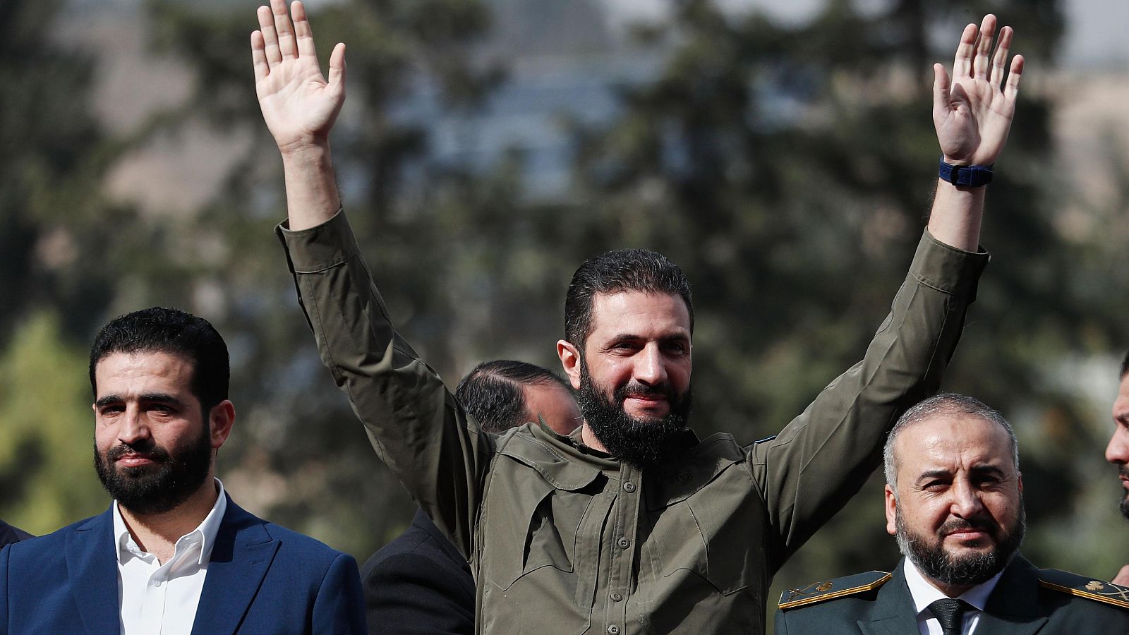 El presidente interino de Siria, Ahmad al Shara, saluda a la gente mientras asiste a las celebraciones que conmemoran el primer aniversario del derrocamiento de Bashar Assad en Damasco.