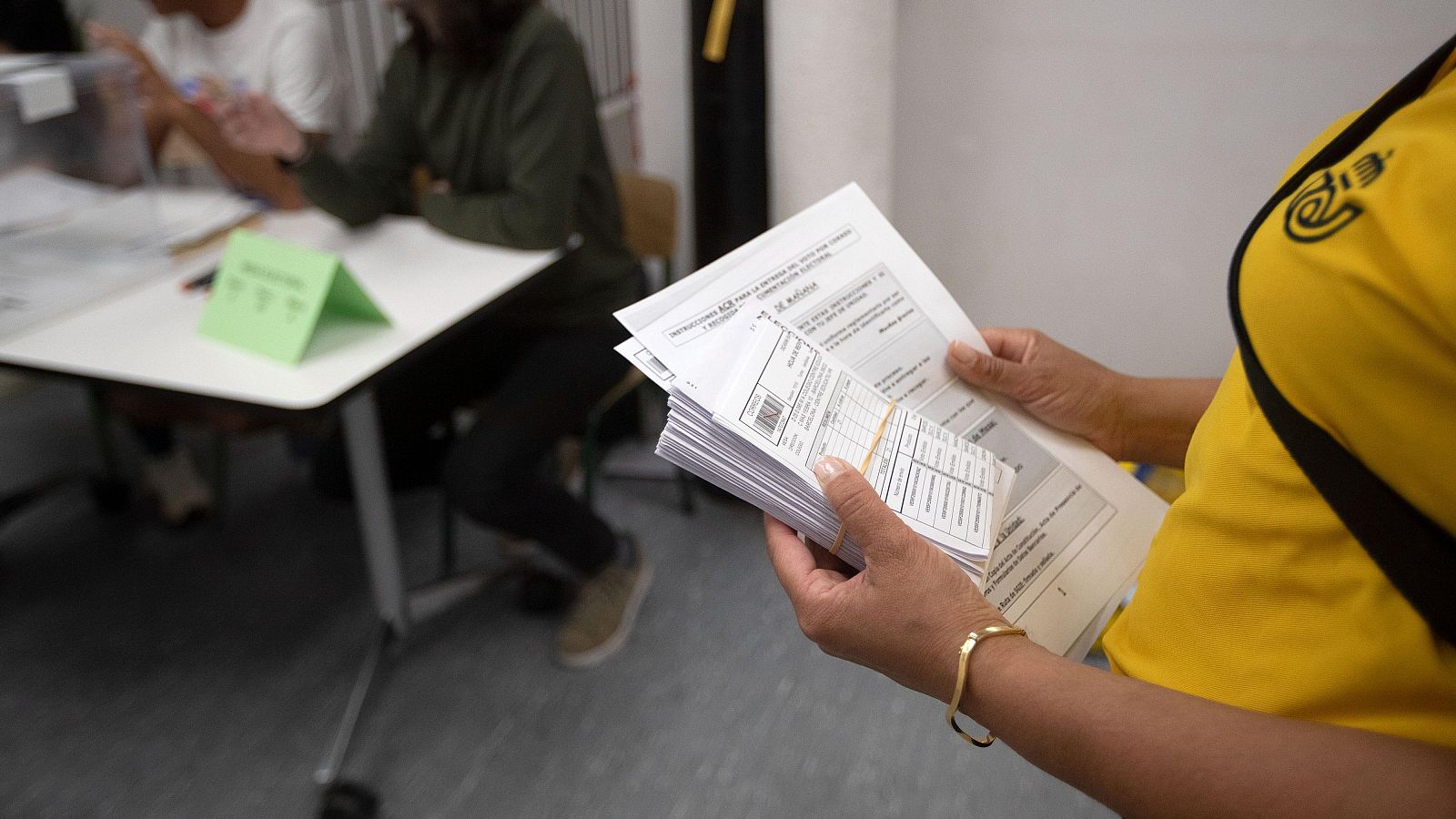 Una trabajadora de correos porta los votos por correo para entregarlos al presidente de una mesa electoral
