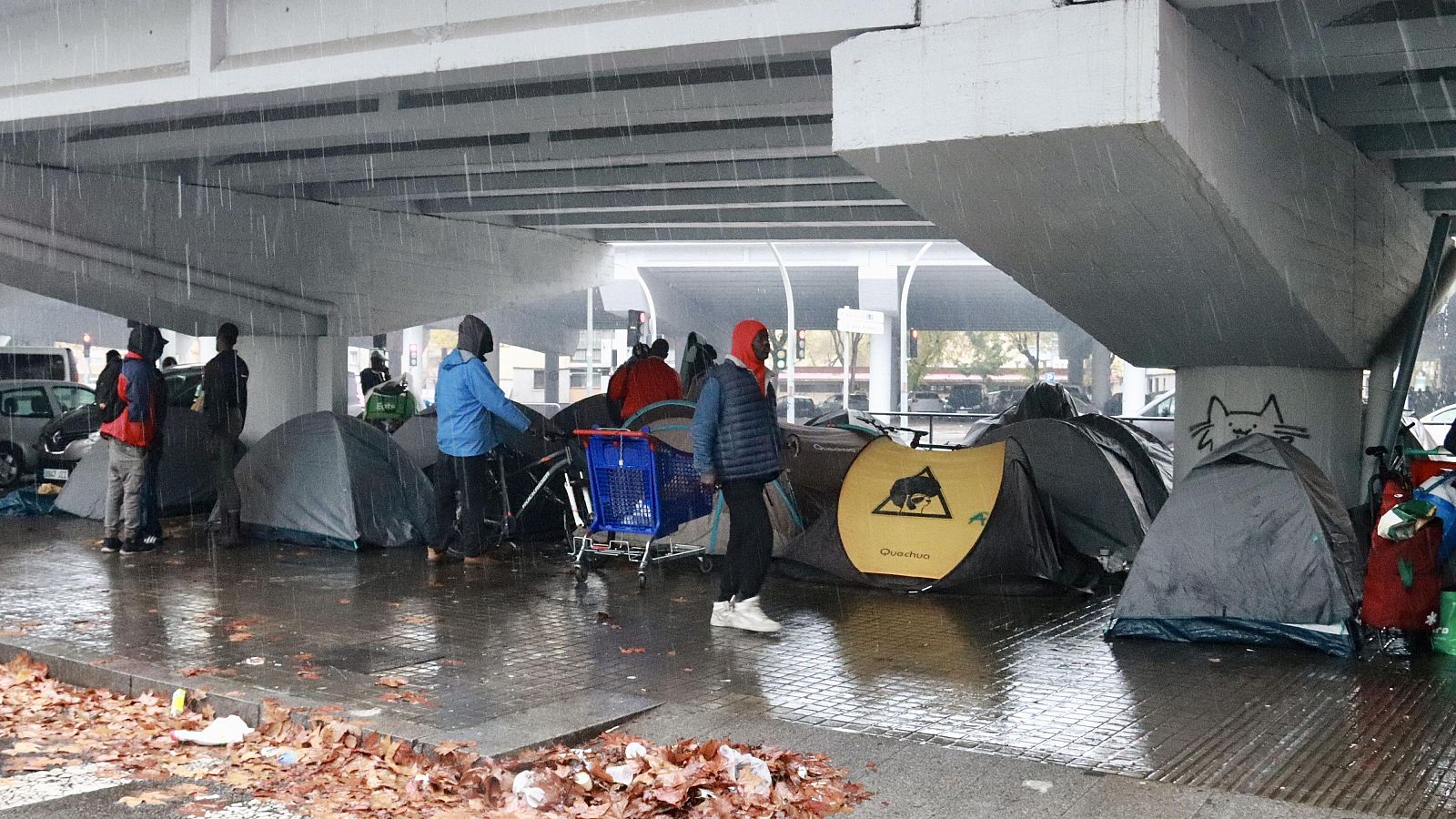 Acampada dels desallotjats de l'edifici B9 sota l’autopista C-31, on s'han aixoplugat mentre plovia fort aquest dissabte a Badalona