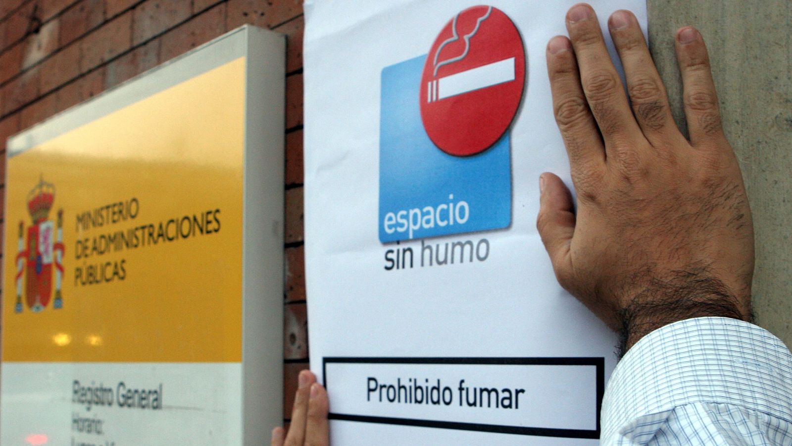 Colocación de un cartel de prohibido fumar por la entrada en vigor de la ley antitabaco en 2006