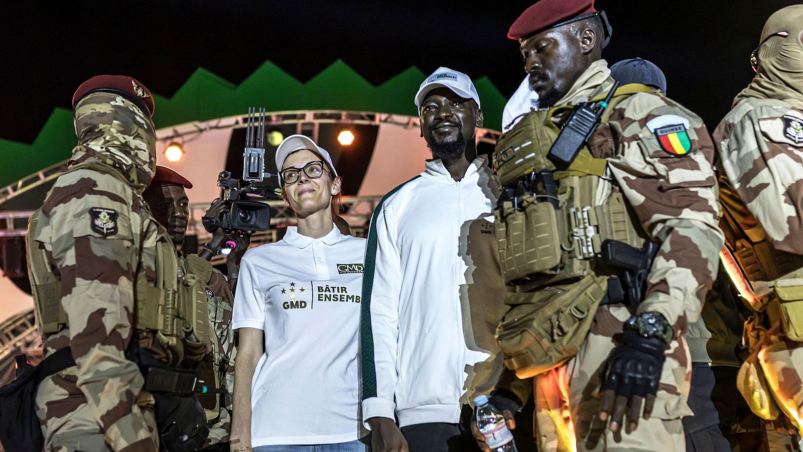 El presidente de Guinea y candidato presidencial Mamady Doumbouya saluda a sus seguidores junto a su esposa.